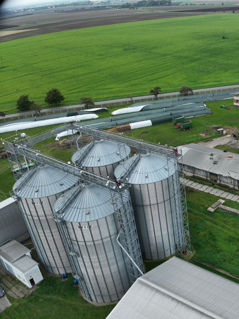 Úvodní obrázek společnosti C H Agro, traktory, sýpky, lidé.